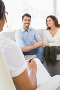 Attending couples counseling or therapy, like the couple pictured, is a big step in learning how to stop blaming others in relationships.